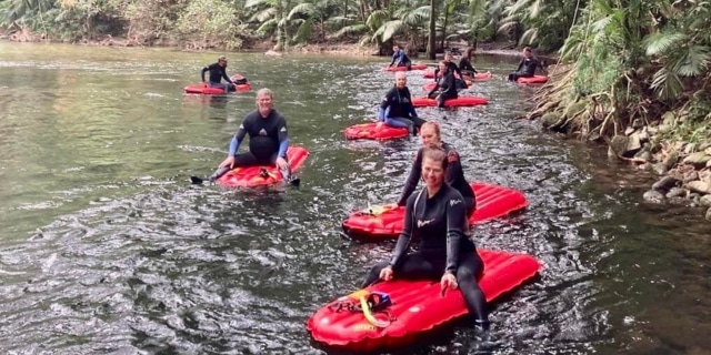 300 international travel agents will sample the best of Tropical North Queensland during a week-long stay in Cairns. Adults floating in a creek on inflatable devices.